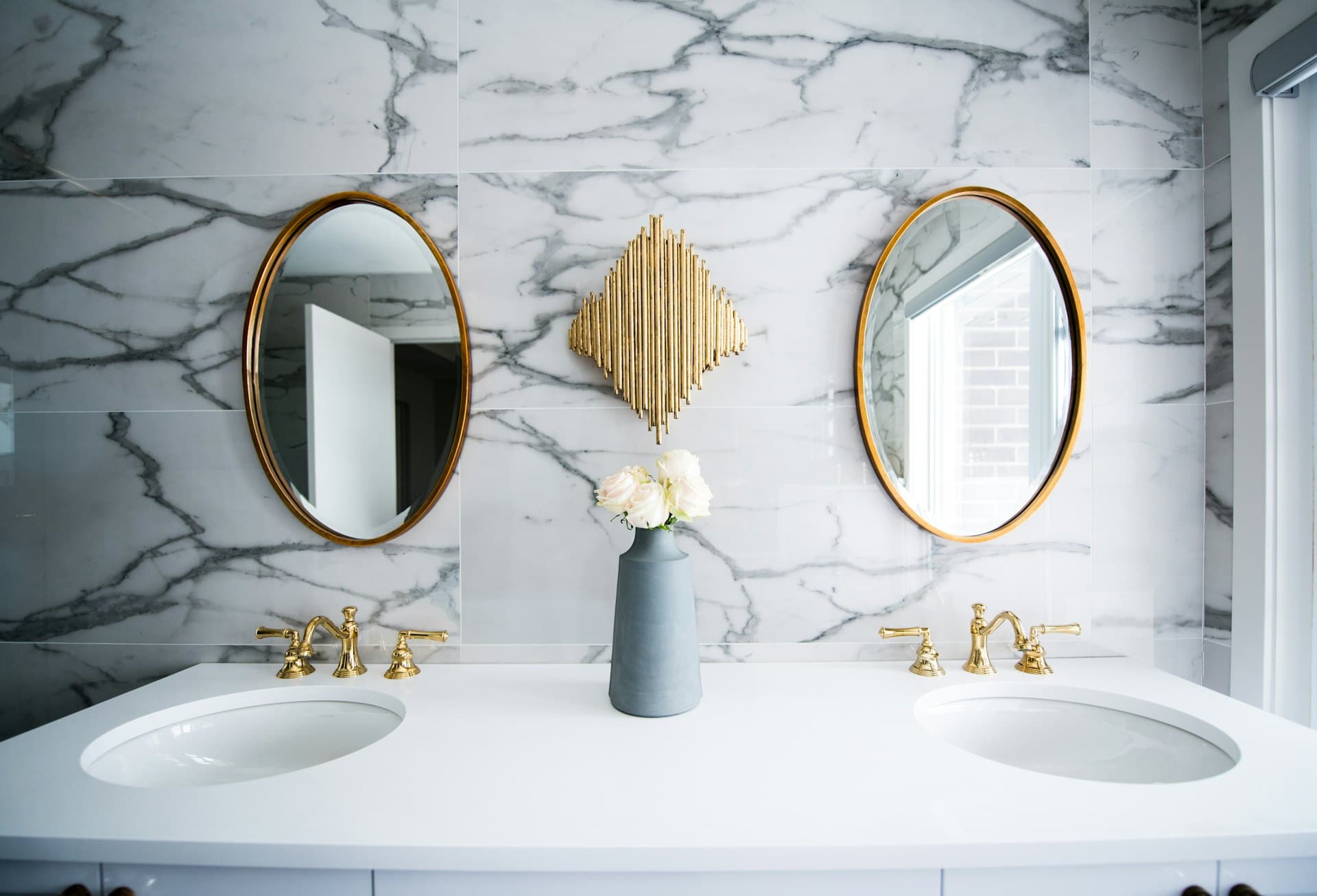 Marble bathroom with twin vanities and gold taps